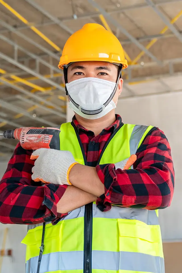 Construction worker with drill and mask