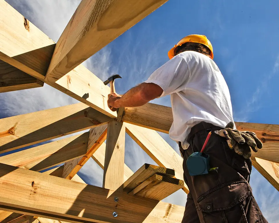 Worker assembling wooden roof frame