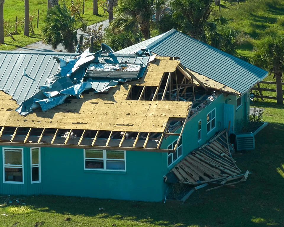 Storm-damaged home with missing roof sections