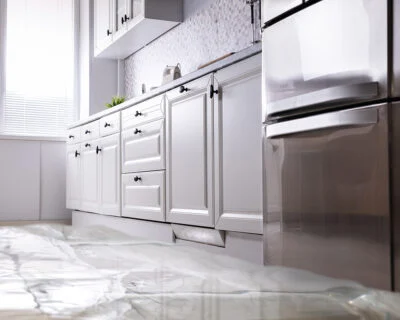 Flooded kitchen with white cabinets